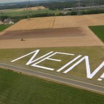 Die von Stromleitungen überspannte Fläche wird hier deutlich. Die Höhe der Buchstaben entspricht der Breite der Mastausleger: 40 Meter. Die Höhe der neuen  Masten: 75 Meter.