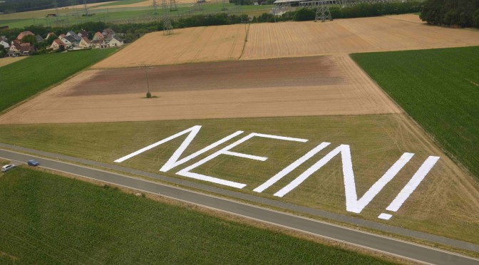 Die von Stromleitungen überspannte Fläche wird hier deutlich. Die Höhe der Buchstaben entspricht der Breite der Mastausleger: 40 Meter. Die Höhe der neuen  Masten: 75 Meter.